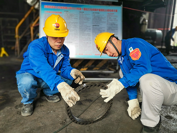 圖三：12日下午14時，在一期磨煤機廠房，陜西省技術能手姬霄給青工張跟潮講解磨煤機搖臂曲拐內環(huán)及動作原理。.jpg